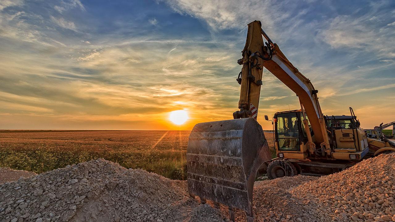 Excavator in construction site at stunning sunset